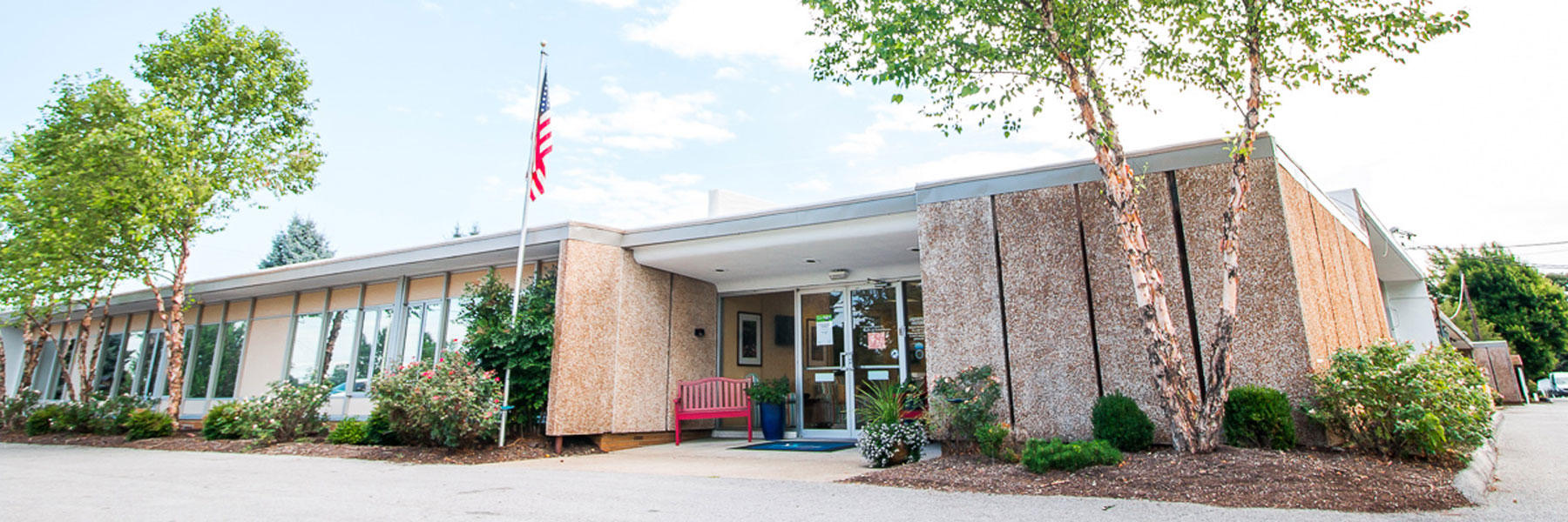 Front entrance of Danville Centre with an American flag and landscaped walkway.